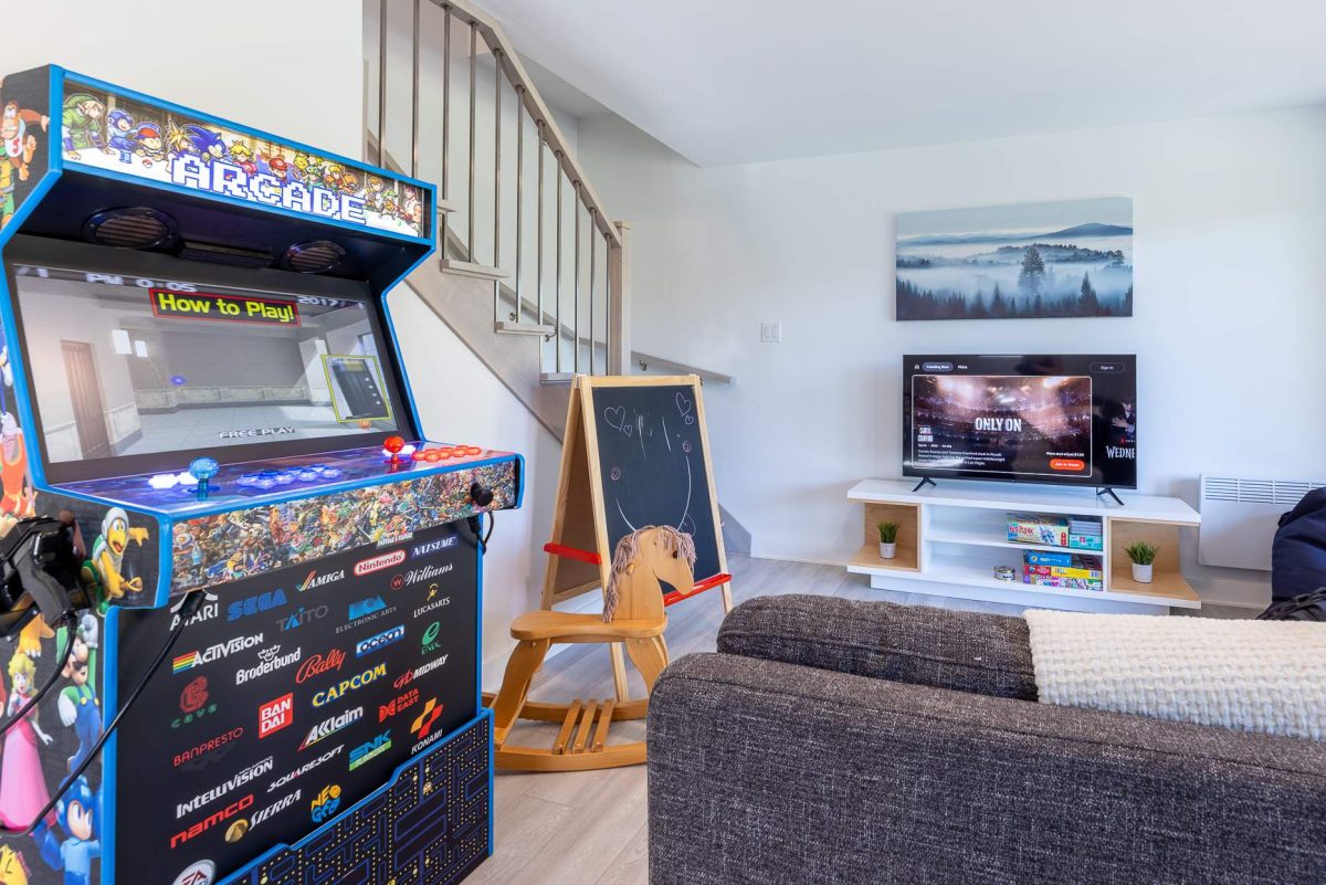 Borne d’arcade et chevalet ardoise dans le salon familial, téléviseur et jeux de société